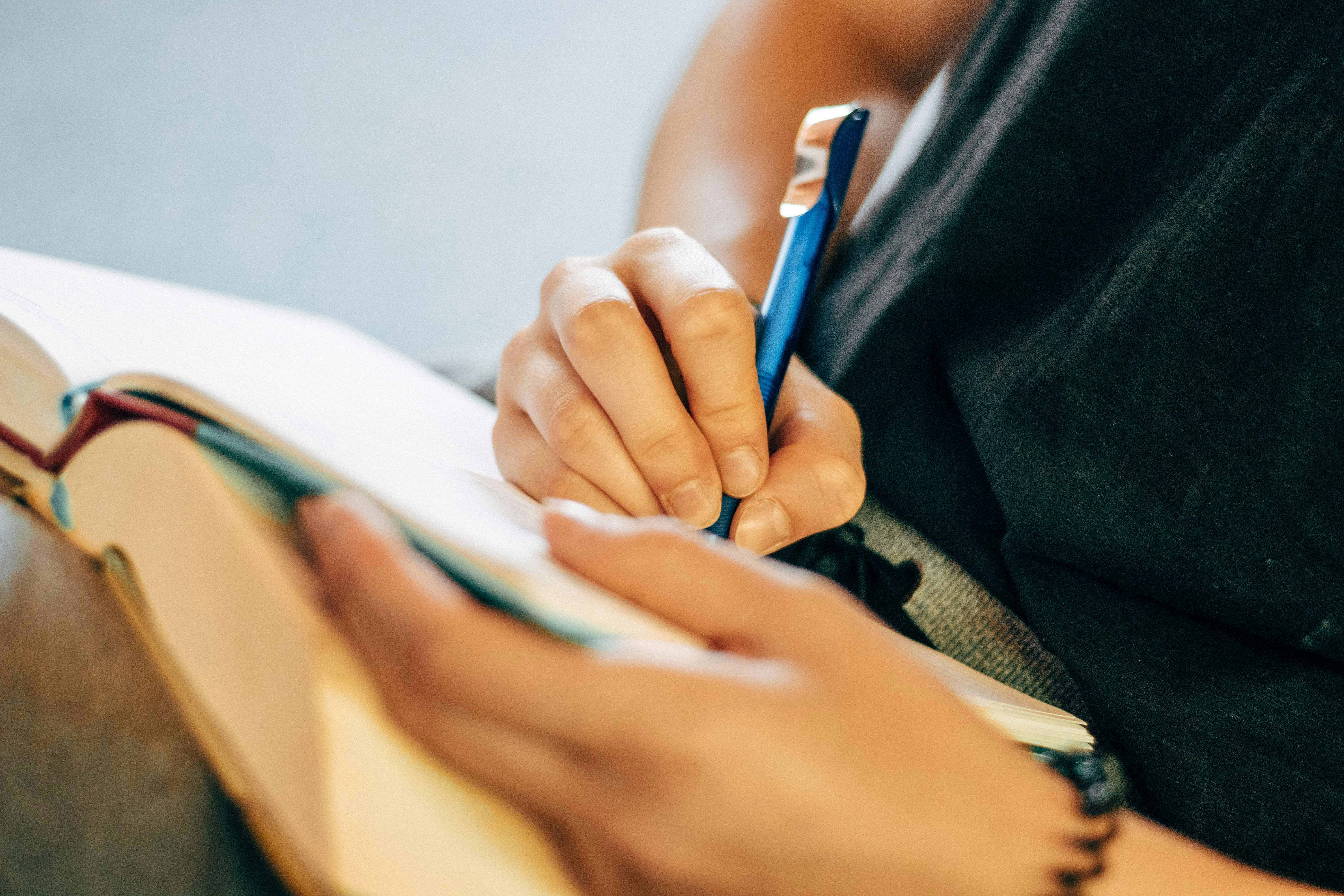 Person Writing Notes in notebook for The Field and the Fishes